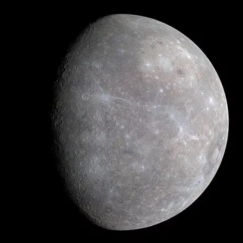 The grey, cratered planet Mercury against a black sky